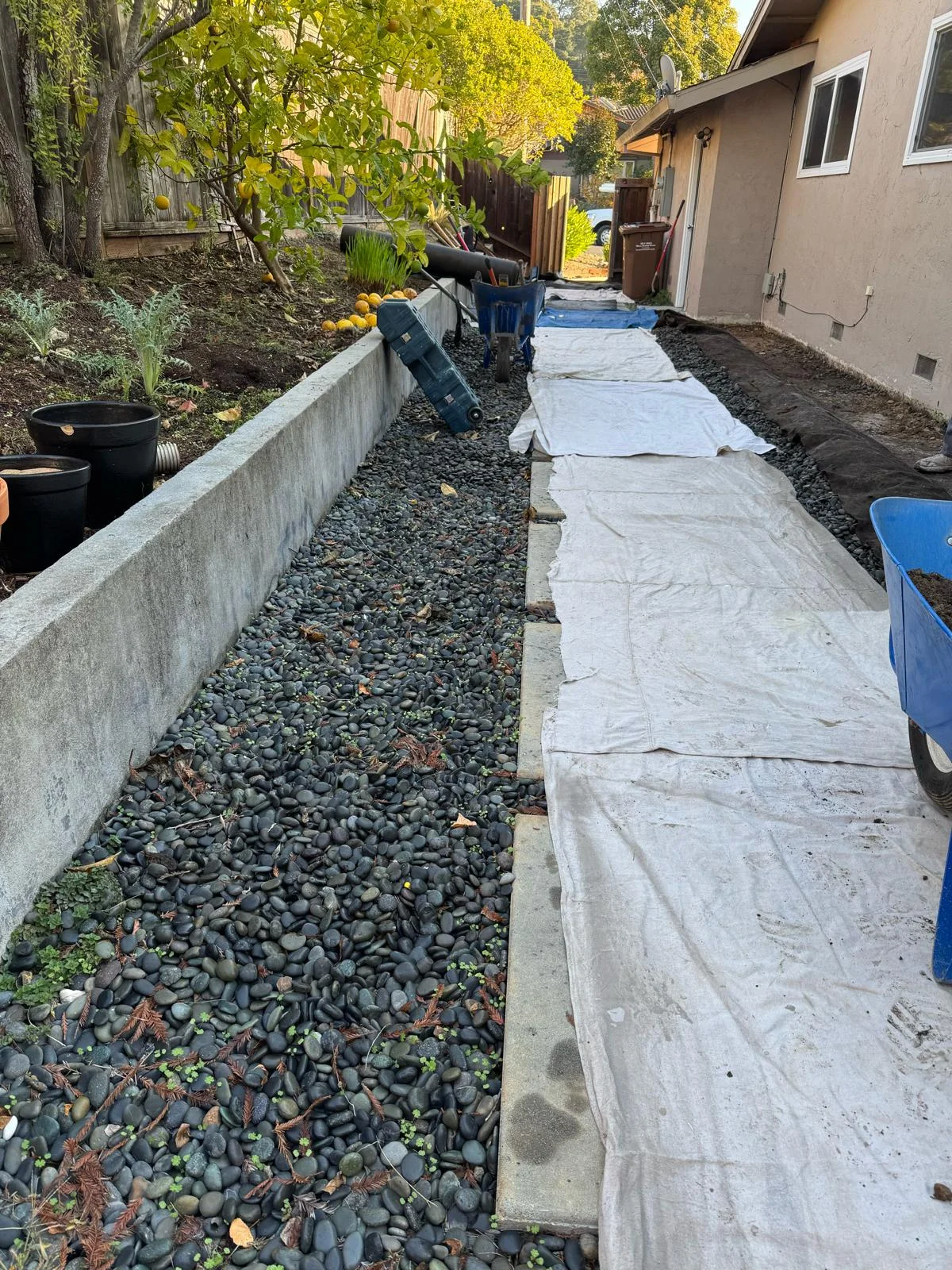 Original drainage installation showing a gravel-filled trench beside a home